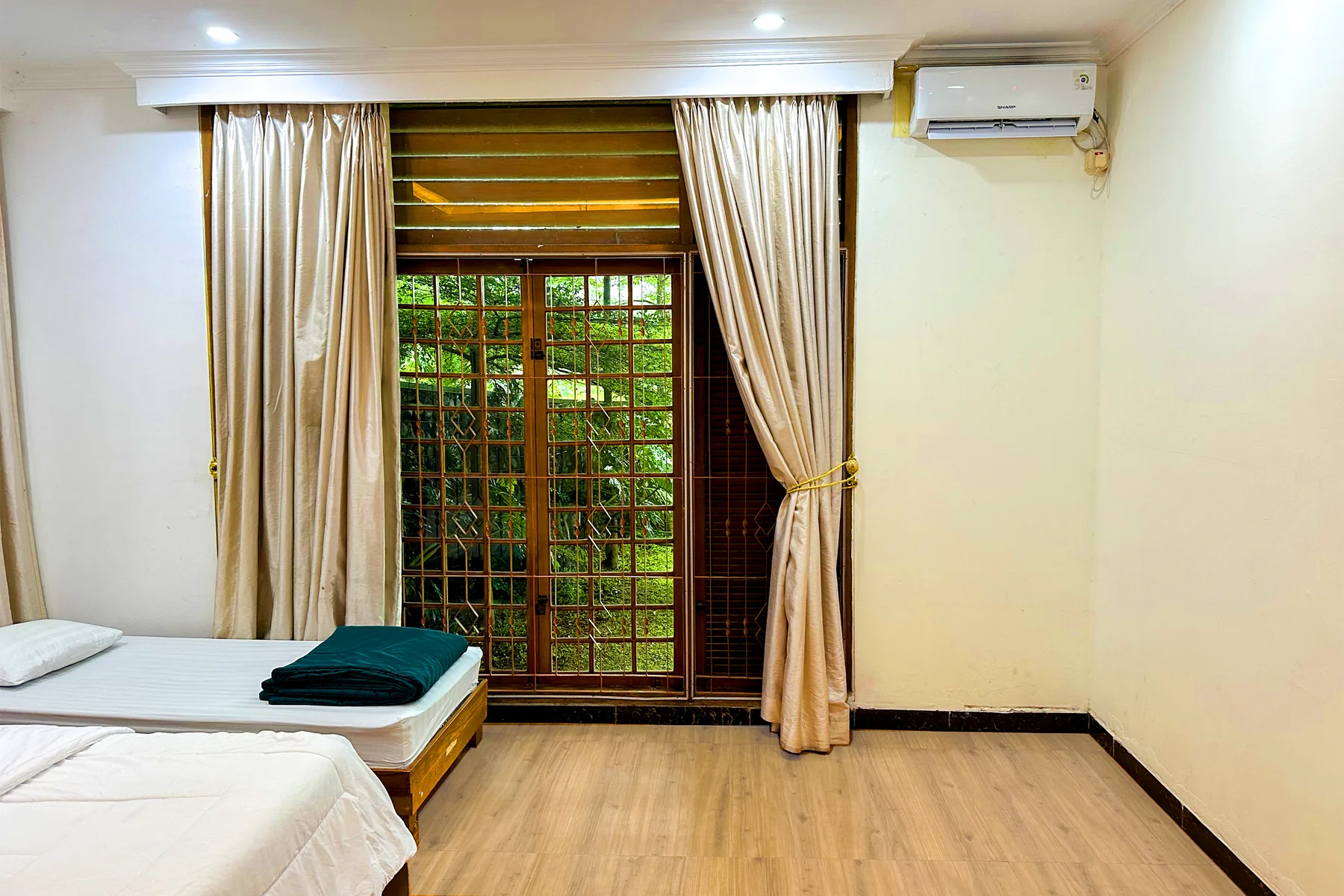 Kamar tidur dengan cahaya alami dan pemandangan hijau